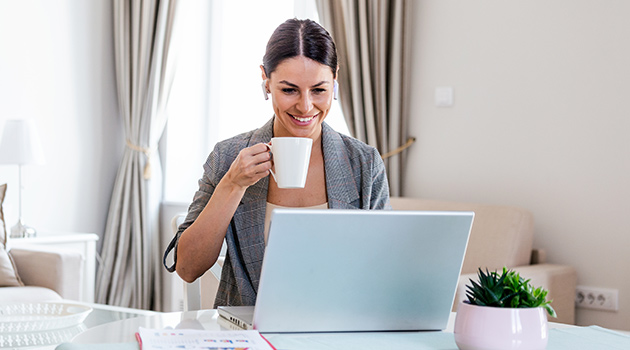 Virtuelle Kaffeepause Frau macht eine virtuelle Kaffeepause vor dem Laptop